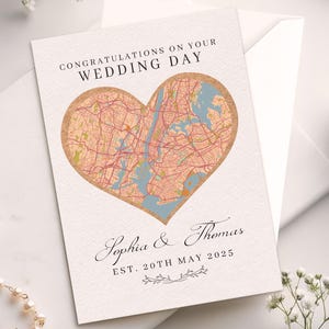 May include: A wedding card with a heart-shaped map of a city, featuring the text "Congratulations on Your Wedding Day." The card includes the names "Sophia & Thomas" and the date "Est. 20th May 2025."