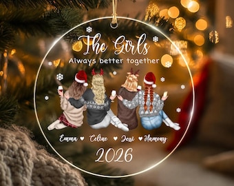 May include: A round, clear acrylic Christmas ornament featuring an illustration of four people from behind, wearing winter sweaters and Santa hats, holding wine glasses. Text reads: The Girls, Always better together, Emma, Celine, Jessi, Hamony, 2026.