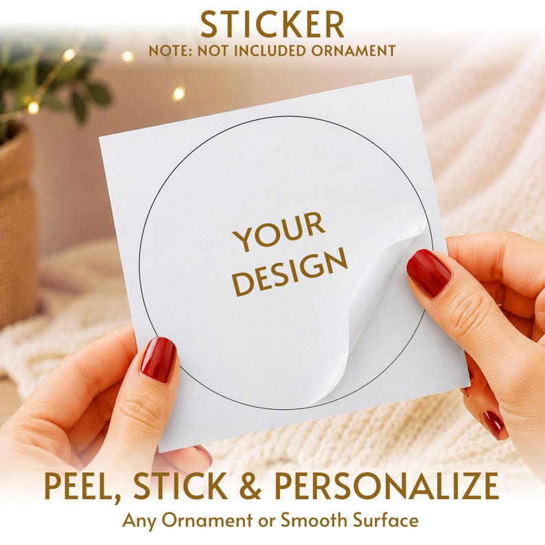 May include: A square white sticker sheet featuring a circular die-cut outline and the gold text YOUR DESIGN in the center. The sticker is partially peeled back from the backing paper. Text on the image reads STICKER, NOTE: NOT INCLUDED ORNAMENT, PEEL, STICK & PERSONALIZE, Any Ornament or Smooth Surface.