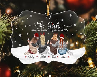 May include: A clear, scalloped-edge ornament featuring a printed illustration of four people from behind, wearing winter clothing and Santa hats, holding drinks. Text reads: the Girls Always better together 2026, with names Vicky, Celine, Anna, and Rosie.