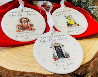 May include: Three round white ceramic ornaments with white ribbon hangers. Each features a watercolor illustration of a front door with a wreath, the text "FIRST CHRISTMAS IN Our New Home," a custom address, names, and the year 2026 printed in black.