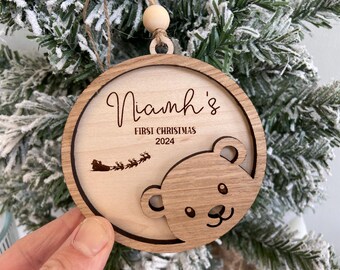 May include: A wooden Christmas ornament with a bear cutout and the text "Niamh's First Christmas 2024".