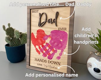 May include: Wooden framed sign with the words "Best Dad Ever" and two handprints in pink and red paint. The sign also includes the text "Hands Down" and "Love... Lucy & Noah xx".