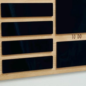 May include: A wooden weekly planner with black chalkboard-style sections for each day of the week, Sunday through Thursday, and a larger section labeled "To Do".