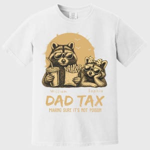 May include: White t-shirt with a graphic of two raccoons wearing sunglasses, holding a drink and fries. The text "DAD TAX" and "MAKING SURE IT'S NOT POISON" are printed below the raccoons. The names "William" and "Sophia" are also printed.