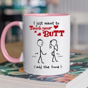 May include: White ceramic mug with a pink handle and rim. The mug features the text "I just want to Touch your BUTT all the time" in red and black, with stick figures of a man and woman.