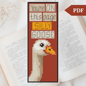 Könnte beinhalten: Kreuzstich-Lesezeichen mit einer weißen Gans mit gelbem Schnabel und orangefarbenen Augen. Das Lesezeichen hat einen roten Hintergrund mit dem Text "You're ON this page SILLY GOOSE" in Gelb.