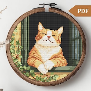 May include: A cross-stitch pattern of a smiling orange tabby cat looking out a window. The cat is sitting with its paws crossed and has its eyes closed. The window is framed in green and has a white sill. There are green leaves on either side of the cat.