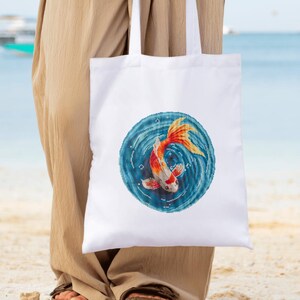 May include: White tote bag with a colorful fish design. The fish is orange, red, and white and is swimming in a blue circle with white swirls.