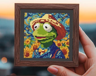May include: A framed cross-stitch of a green frog wearing a brown hat, surrounded by sunflowers. The background is a blue and yellow starry night scene. The image is 65 stitches by 65 stitches.