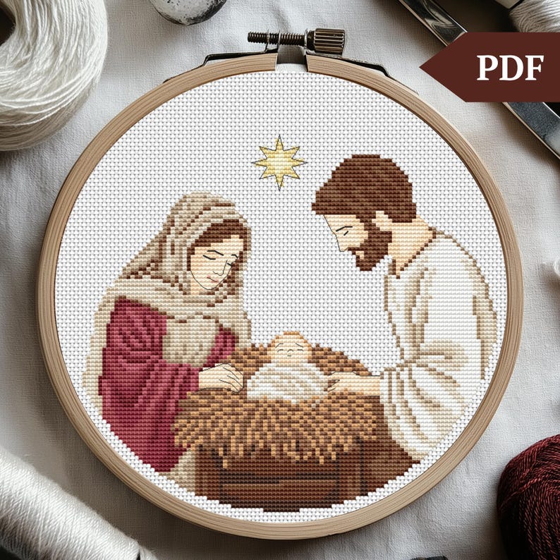 May include: A cross-stitch pattern of the nativity scene with Mary, Joseph, and baby Jesus in a manger. The scene is set against a white background with a star above the manger.