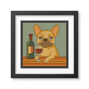 Könnte beinhalten: Gerahmtes Kreuzstich-Kunstwerk mit einem hellbraunen Französischen Bulldoggen, der ein Weinglas hält. Links ist eine Weinflasche. Der Hintergrund ist hellgrün und der Tisch braun. Das Kunstwerk ist in einem schwarzen Rahmen.