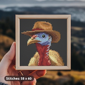 May include: Cross-stitch art of a turkey wearing a cowboy hat, framed in a wooden square. The turkey has a blue head, red wattle, and a tan body. The background is a dark gray grid. The text "Stitches: 58 x 60" is at the bottom.
