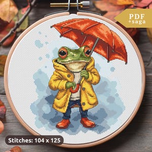 May include: Cross stitch pattern of a frog wearing a yellow raincoat and holding a red umbrella. The pattern is 104 stitches wide by 125 stitches tall.