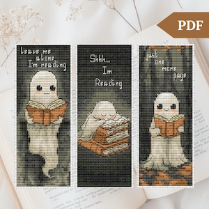 May include: Three printable bookmark designs featuring a cute ghost reading a book. The first bookmark says "Leave me alone I'm reading". The second bookmark says "Shhh... I'm reading". The third bookmark says "Just one more page".