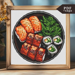 以下が含まれることがあります： サーモン、海藻、ご飯の入った寿司の皿のクロスステッチパターン。パターンは白地に黒枠です。