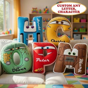 May include: A collection of plush letter pillows in various colors, each designed to resemble a cartoon car character. The pillows are in the shape of the letters H, C, O, P, and M, with names like Harold, Charles, Oliver, Peter, and Mary.
