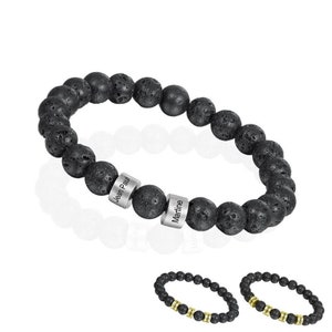 May include: Black lava rock beaded bracelet with two silver name tags, one reading "Jean Paul" and the other reading "Martine". Two additional bracelets with black lava rock beads and gold accents are shown below.