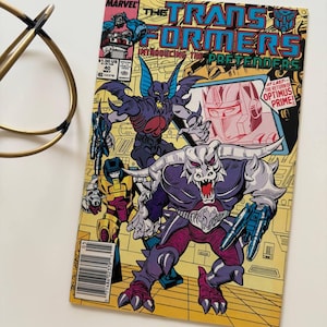 May include: A vintage comic book titled "The Transformers: Introducing The Pretenders" with vibrant illustrations of robotic characters. The cover art includes the Marvel logo, issue number 40, and the text "The Return of Optimus Prime!"