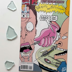 May include: A comic book featuring Beavis and Butt-Head, with the text "FIRST ISSUES ARE COOL!!!". The cover art depicts a dental scene with the characters. The comic is a Marvel Comics Direct Edition.