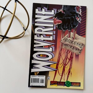 May include: A comic book titled "Wolverine" with a cover featuring a clawed hand and the text "Princess Bar". The comic has a February date and the Marvel Comics Deluxe logo. The cover is predominantly black, red, and yellow.