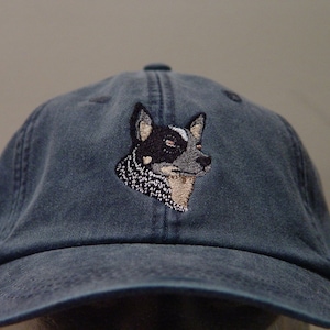 Puede incluir: Una gorra de béisbol azul oscuro con una imagen bordada de un perro blue heeler.