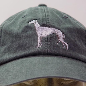 May include: A dark green baseball cap with a white embroidered image of a greyhound dog.