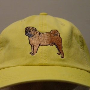 Puede incluir: Una gorra de b&eacute;isbol amarilla con una imagen bordada de un perro carlino.