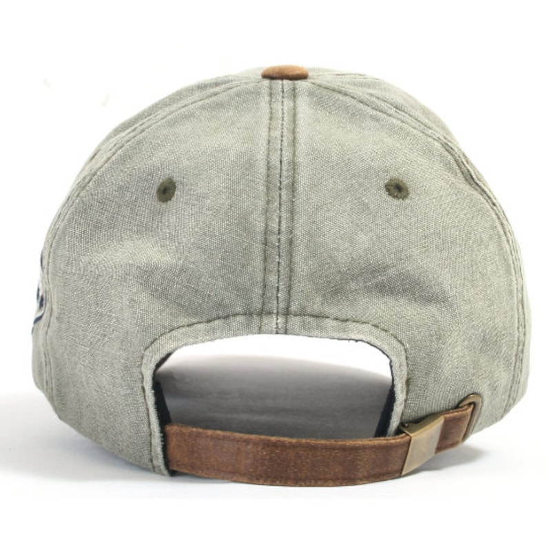 May include: A green canvas baseball cap with a brown leather strap and a metal buckle. The cap has a slightly distressed look.
