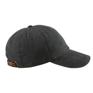 Puede incluir: Una gorra de b&eacute;isbol de algod&oacute;n negro con una correa de cuero marr&oacute;n.