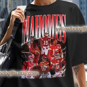 May include: Black t-shirt featuring the name "MAHOMES" in red and white, with a graphic of football players in red and white uniforms. The text "yellowbobgifts.etsy.com" is also visible on the shirt.