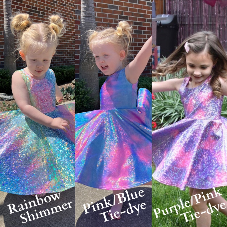 May include: Three girls wearing iridescent tie-dye dresses. The dresses are rainbow shimmer, pink and blue tie-dye, and purple and pink tie-dye.