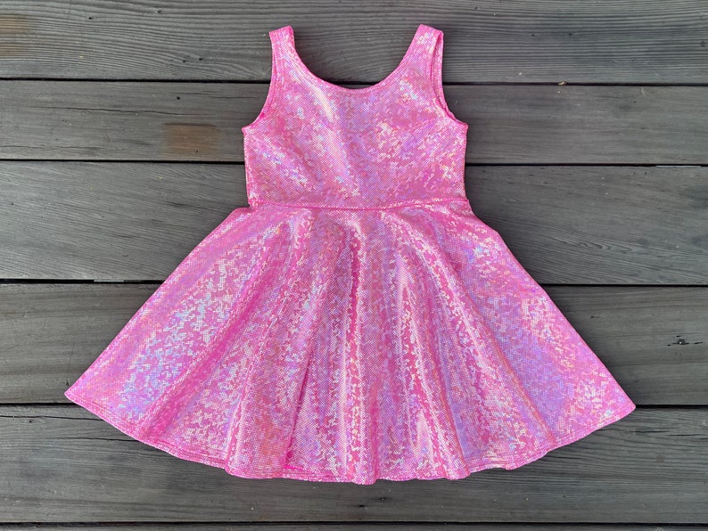 May include: A pink iridescent sleeveless dress with a flared skirt.