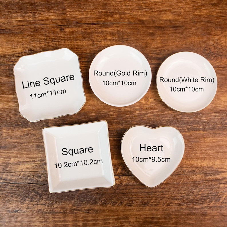 May include: Five white ceramic dishes in various shapes: a line square (11cm x 11cm), a round with a gold rim (10cm x 10cm), a round with a white rim (10cm x 10cm), a square (10.2cm x 10.2cm), and a heart (10cm x 9.5cm).