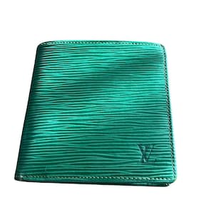 Może przedstawiać: Żywy zielony skórzany portfel z teksturowaną, prążkowaną powierzchnią. Portfel ma szytą obwódkę i subtelne wytłoczone logo w prawym dolnym rogu. Portfel jest prostokątny i wydaje się zamknięty.