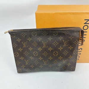 Puede incluir: Bolsa con monograma marrón y beige con cremallera dorada. La bolsa tiene un patrón repetido de letras entrelazadas y formas florales. Una caja de cartón con el nombre de la marca está en el fondo.