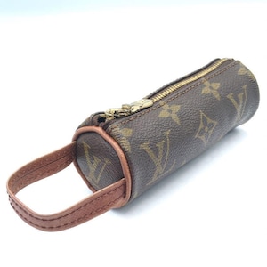 May include: Brown cylindrical handbag with a gold zipper and a small brown handle. The bag features a repeating pattern of brown logos on a brown background. The zipper is gold-colored.