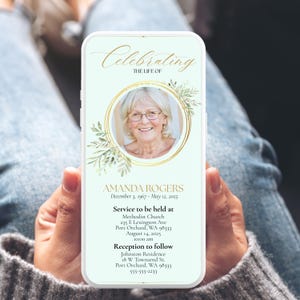 May include: A smartphone displaying a memorial announcement. The design features a photo of a woman in a gold circular frame, with the text "Celebrating the Life of" and the name "AMANDA ROGERS". Additional text includes dates, service details, and a reception location.