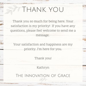 May include: A white card with the words "THANK YOU" at the top, followed by a message of gratitude. The text is in a simple, elegant font. The card is on a white wooden background.