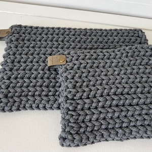May include: Two gray knitted pot holders with leather tags that say "PT Designs".