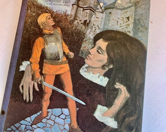May include: A vintage book cover with an illustration of a man in armor holding a sword and a woman with long brown hair. The book title is "The Sleeping Beauty and Other Tales" by The Brothers Grimm.