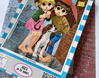 May include: Vintage Milton Bradley puzzle featuring a retro illustration of two children and a dog under an umbrella in the rain. The puzzle box reads "April Showers" and "Ages 10 to Adult."