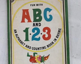 May include: Vintage children's book titled "Fun With ABC and 123." The cover features large, colorful letters and numbers, with a whimsical illustration of a clown. The book is an alphabet and counting book in rhyme, published by Parents' Magazine Press.