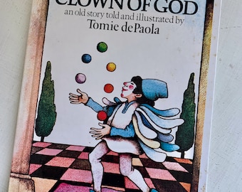 May include: The Clown of God, an old story told and illustrated by Tomie dePaola, features a colorful illustration of a clown juggling balls in a checkered courtyard.