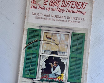 May include: Vintage book cover titled "We Was Different" with "The Tale of an Ugly Thrushling" text. The cover features a window scene with green shutters, a bird, and a person playing a flute. Illustrations by Norman Rockwell.