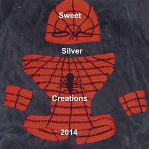 Könnte beinhalten: Rotes und schwarzes gehäkeltes Spiderman-Kostüm mit passender Mütze. Das Kostüm hat ein Spinnennetz-Design und den Text "Sweet Silver Creations 2014".