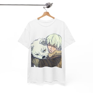 Könnte beinhalten: Weißes T-Shirt mit einer Cartoon-Illustration eines Charakters mit weißen Haaren, der eine weiße wolfsähnliche Kreatur umarmt. Der Charakter trägt eine braune Jacke mit einem Pelzkragen. Das Design ist auf dem Shirt zentriert.