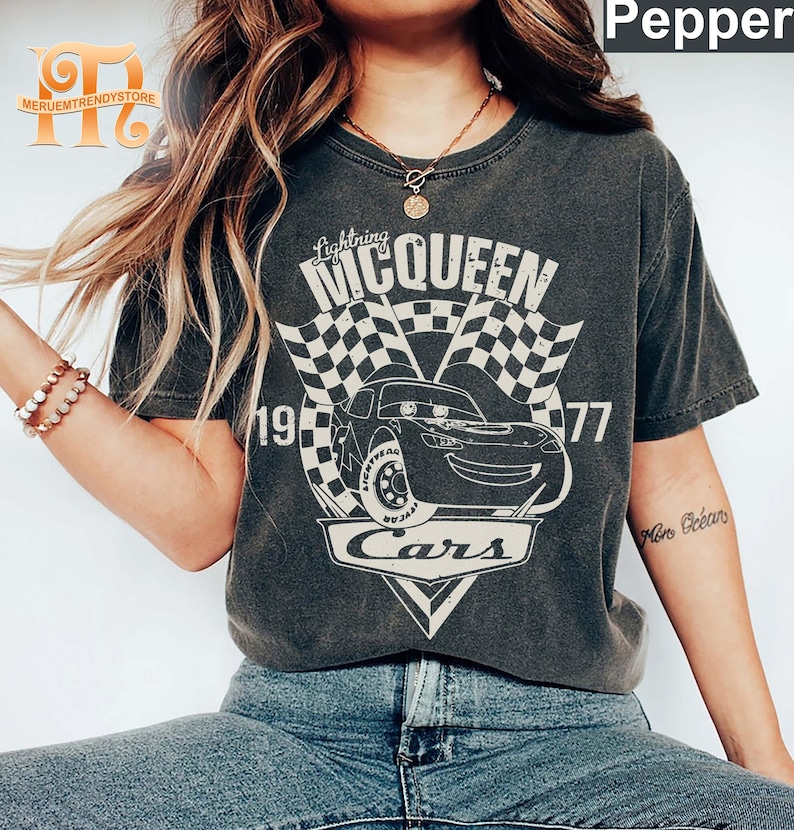 May include: A gray t-shirt with a vintage-style graphic of Lightning McQueen from the Disney Pixar movie Cars. The graphic includes the text "Lightning McQueen", "Cars", and the numbers "19" and "77".
