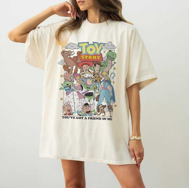 Puede incluir: Camiseta color crema con un gr&aacute;fico colorido de personajes de la pel&iacute;cula animada "Toy Story". El dise&ntilde;o incluye el t&iacute;tulo de la pel&iacute;cula y la frase "You've Got a Friend in Me".