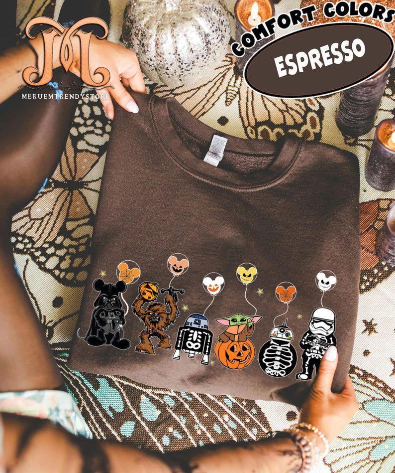 Op de afbeelding: Bruin sweatshirt met een rij Star Wars-personages die ballonnen vasthouden. De ballonnen hebben gezichten die ge&iuml;nspireerd zijn op Mickey Mouse. Op de trui staan de woorden "Comfort Colors" en "Espresso".